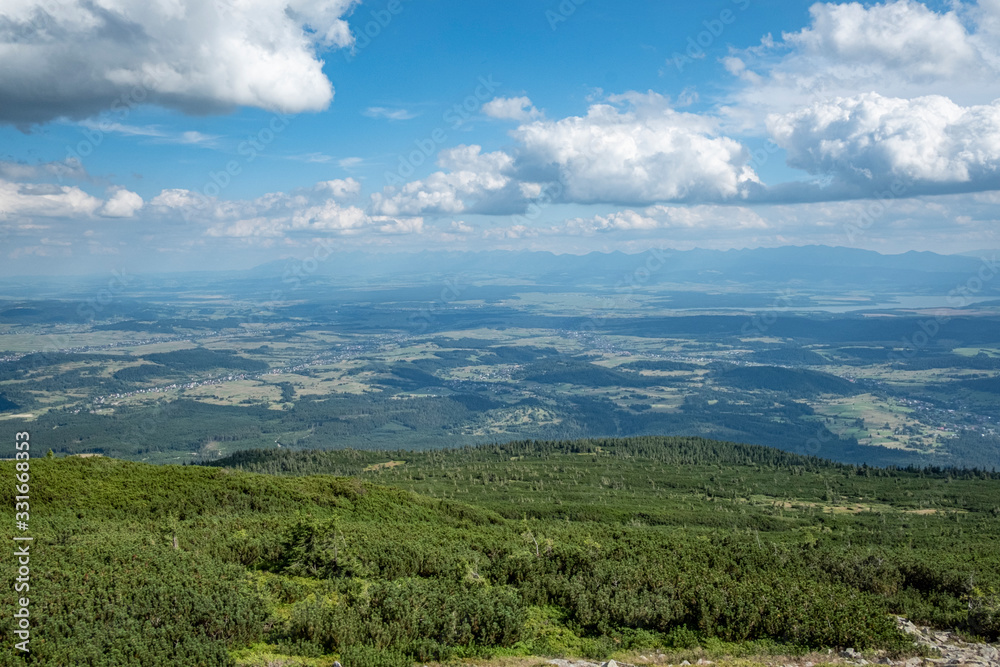 A panorama over a deep valley and the Tatra Mountains seen from the Babia Gora mountain (Sudety)
