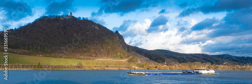 GERMANY, BONN. A cargo ship navigating the Rhine river below castle Drachenfels