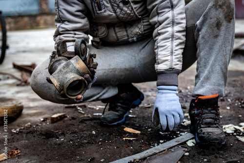 Man collects scrap metal outside. © Natallia