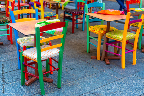 Outdoor furniture Set of coloured wooden chairs arranged in the street