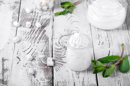 фотографія Marshmallow creme in glass jars on the white wooden table