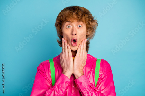 Portrait of astonished guy hear his failure novelty impressed touch hands face scream wear good look clothes isolated over vivid blue color background
