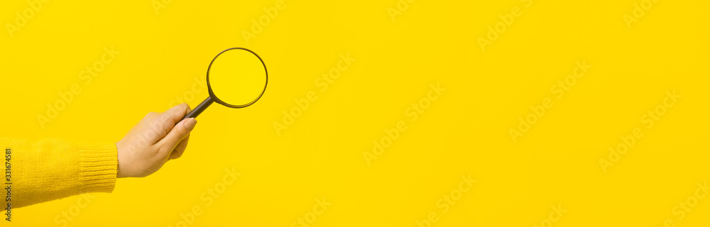 magnifier in hand  over yellow background, panoramic mock-up image - obrazy, fototapety, plakaty 