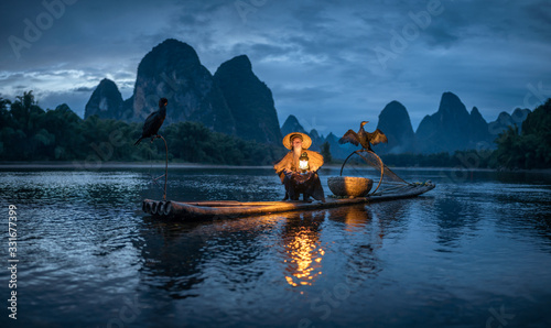 Traditional Chinese cormorant fisherman on the Li River, Guilin, China photo