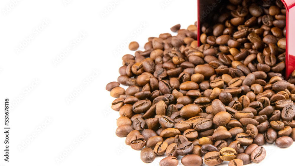Roasted coffee beans spilling out of a metal box isolated on a white background Roasted coffee beans spilling out of a metal box isolated on a white background