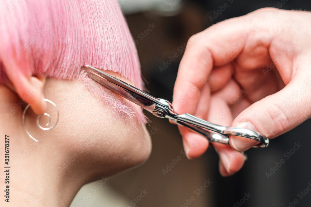 Hand cuts hair of woman. Hand cuts hair of woman.