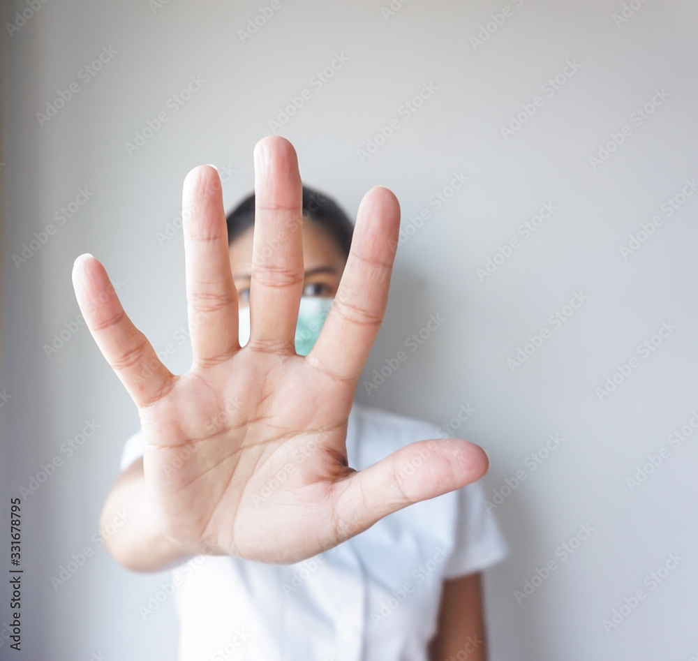 Women in white shirt wearing masks to protect corona virus. Stop hand sign. Stop corona virus. Women in white shirt wearing masks to protect corona virus. Stop hand sign. Stop corona virus.
