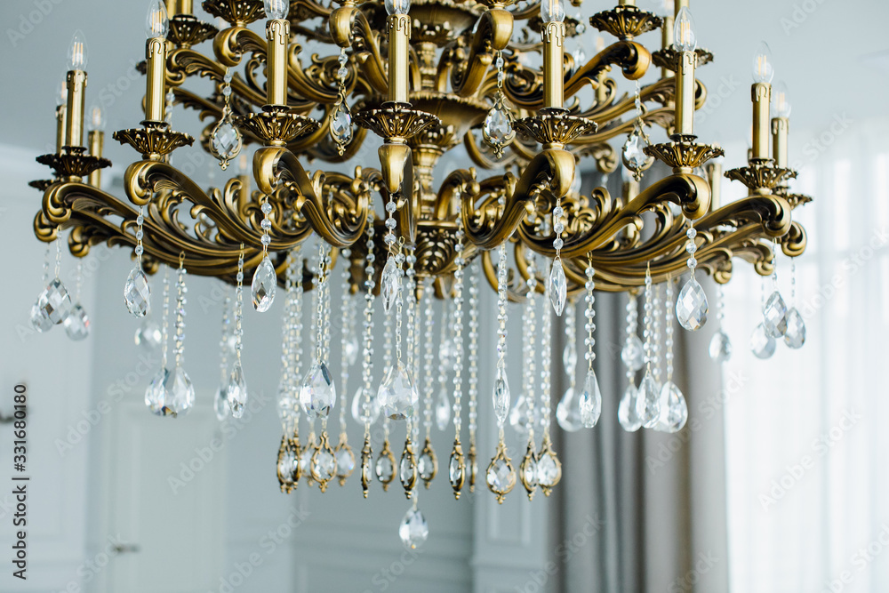 Chandelier Lamp beautiful luxury expensive chandelier hanging under ceiling . The lamp in the beautiful room .Brass chandelier with crystal. Chandelier ceiling lights