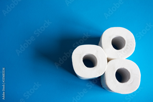  rolls of toilet paper on blue background with space for text
