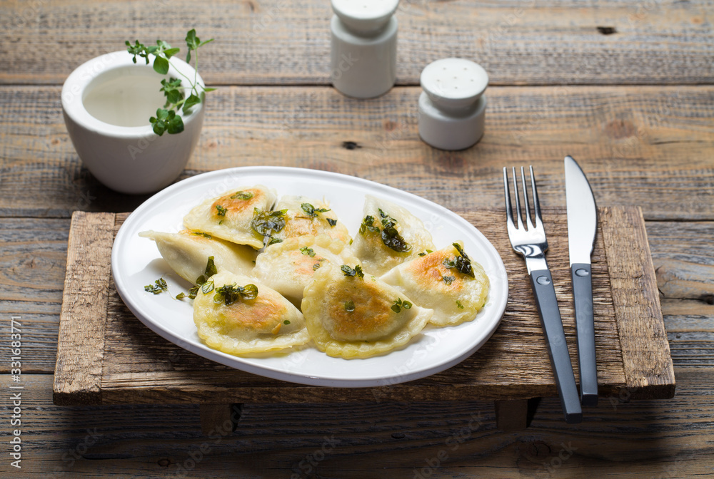 Fried dumplings with herbs on wood.