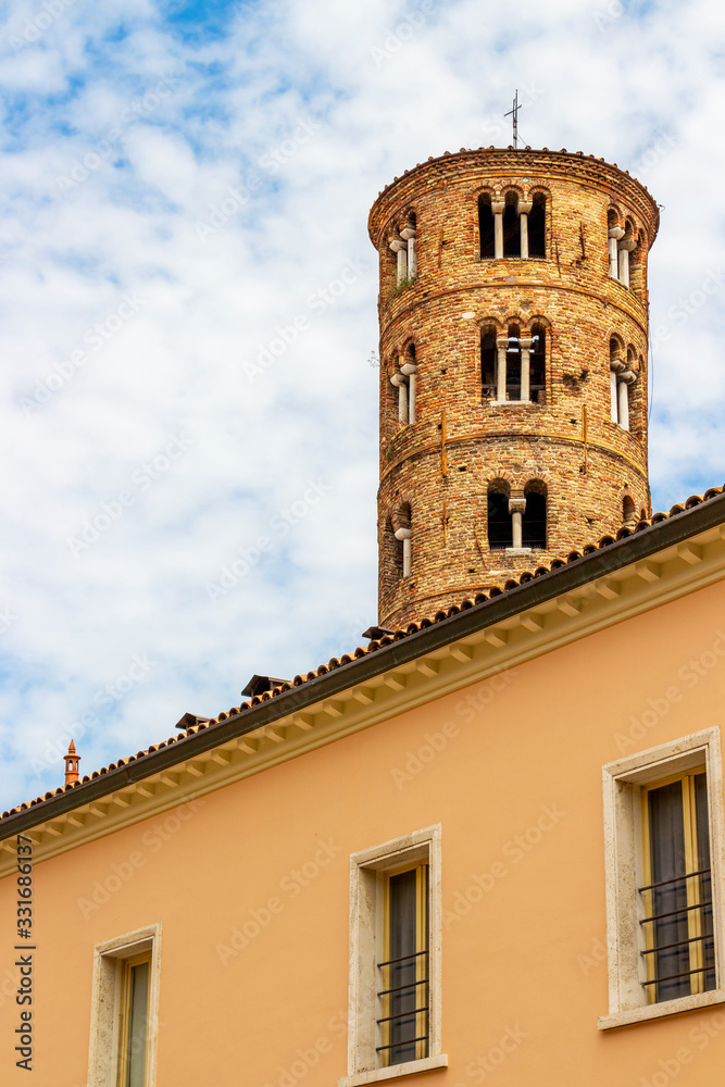 Bell tower of Basilica of Sant'Apollinare Nuovo in Ravenna, Province of Ravenna, Region of Emilia-Romagna, Italy as seen behind a building