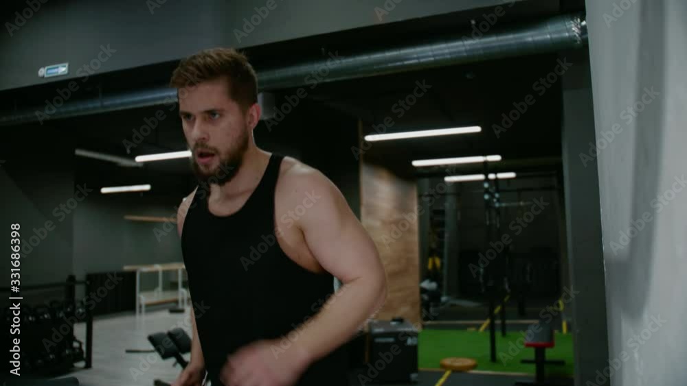 A runner Trains on a treadmill In a Gym, a Male Athlete Tests his endurance On a Treadmill, a Guy with muscles Runs in a rocking chair, an Endurance Test, Training Before a Marathon A runner Trains on a treadmill In a Gym, a Male Athlete Tests his endurance On a Treadmill, a Guy with muscles Runs in a rocking chair, an Endurance Test, Training Before a Marathon