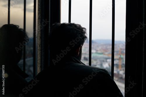 A man looks out the window from the observation deck in