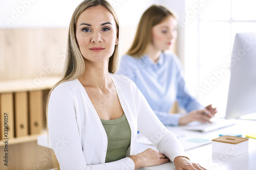 Business woman headshot. Businesspeople or colleagues discussing something at meeting while sitting at the desk in office. Casual clothes style. Audit, tax or lawyer concept © rogerphoto