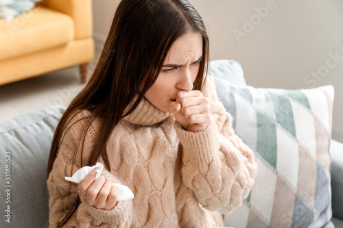 Coughing young woman at home