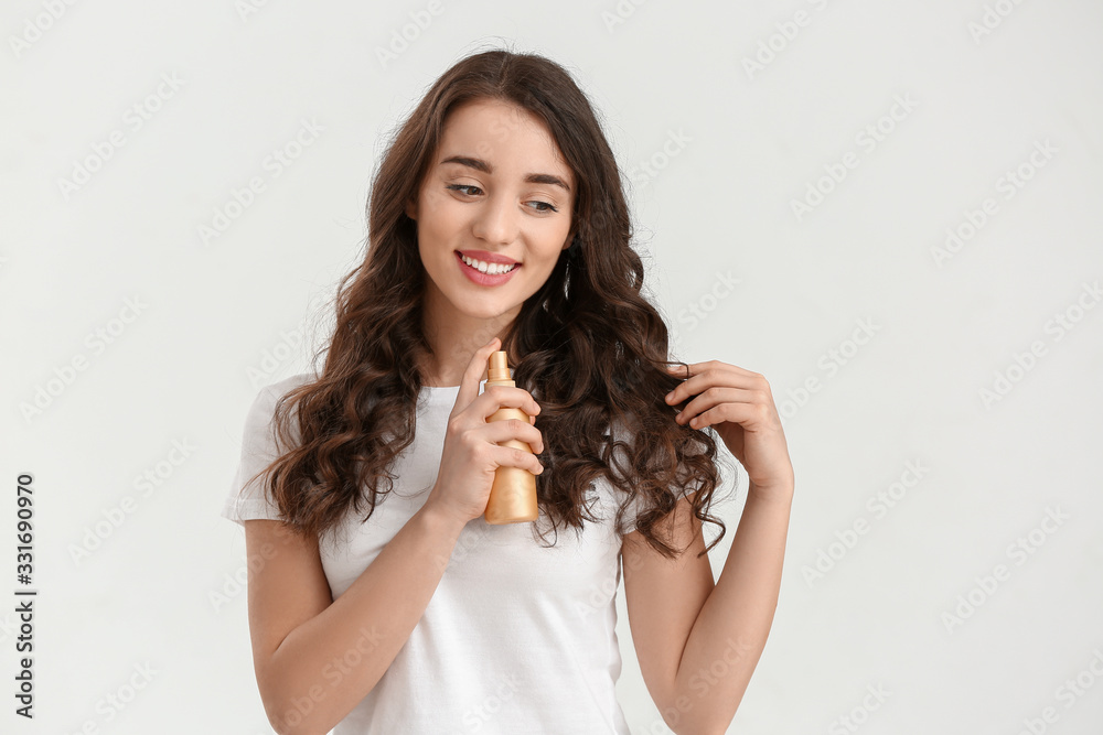 Beautiful young woman with hair spray on white background Beautiful young woman with hair spray on white background