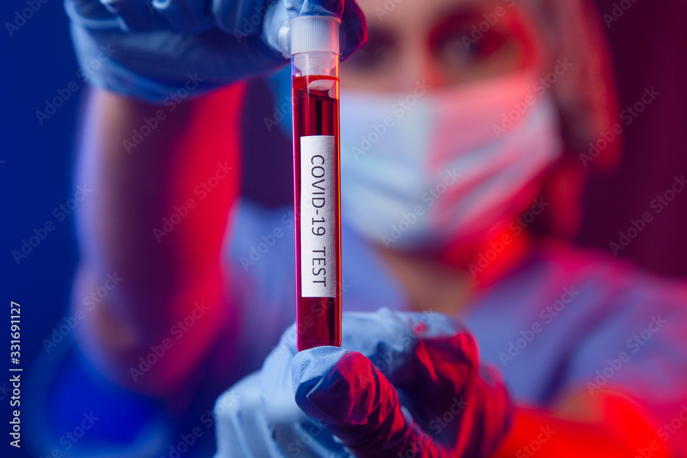 Nurse wearing respirator mask holding a blood test for the new Coronavirus, covid-19. Coronavirus Pandemic Concept. Nurse wearing respirator mask holding a blood test for the new Coronavirus, covid-19. Coronavirus Pandemic Concept.