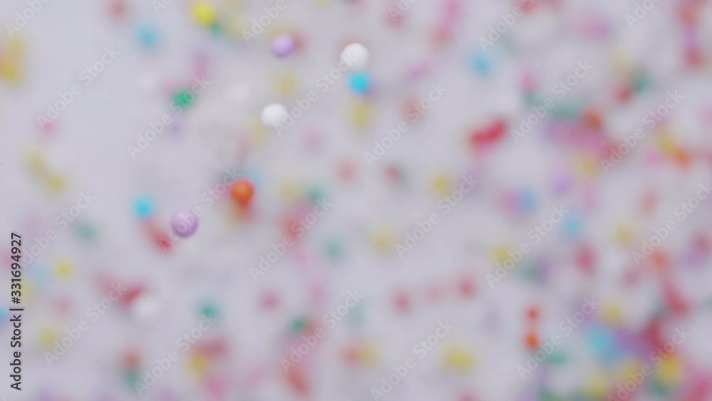 Colorful sprinkles sugar candy fly after being exploded. Slow motion. Close-up shot. Colorful sprinkles sugar candy fly after being exploded. Slow motion. Close-up shot.