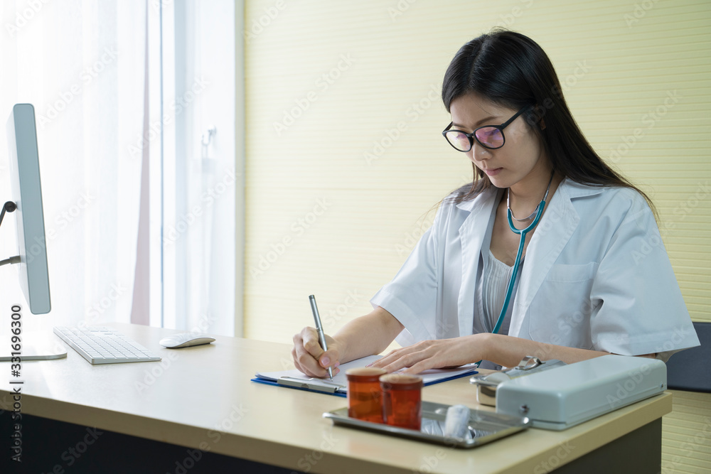 Asian young female doctor is working notes while in his office. Asian young female doctor is working notes while in his office.