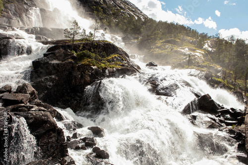 Waterfall Langfossand near power station. National tourist route. Famous landmark in Norway at summer time.