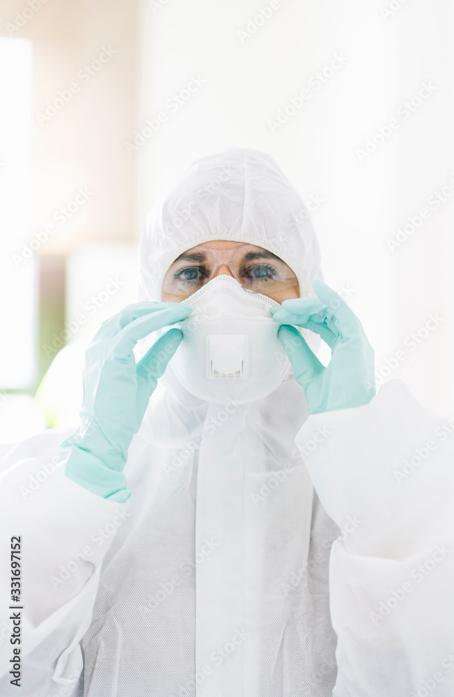 Portrait of protected woman with safety suit, glasses and mask before a pandemic or virus