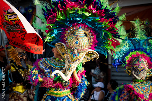 closeup man in colorful elephant costume passes by city street at dominican carnival