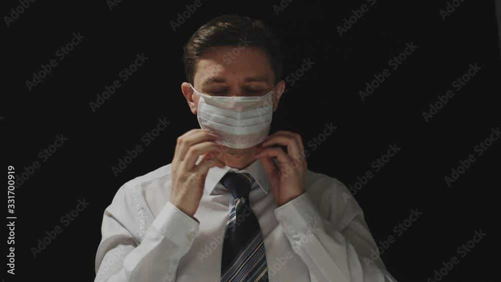 CORONAVIRUS: Businessman shows a mask and put on it CORONAVIRUS: Businessman shows a mask and put on it