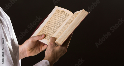 Man with open quran in hands photo