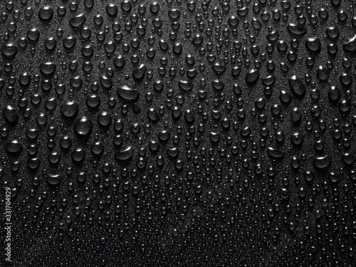 a close-up image of small water drops on a black background. Textured background with water drops. Macro photography