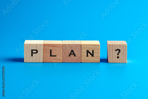 Word plan and a question mark on wooden blocks over blue background