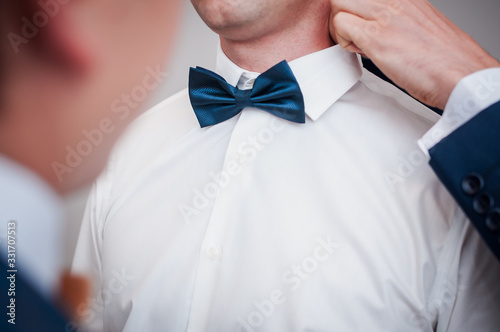 Dark blue bowtie on the grooms neck