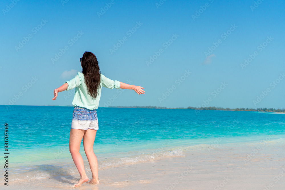 Woman laying on the beach enjoying summer holidays looking at the sea