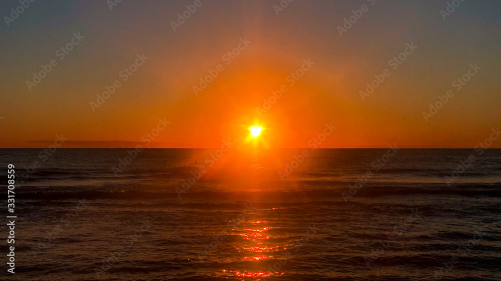red orange sunset / sunrise over the ocean horizon red orange sunset / sunrise over the ocean horizon