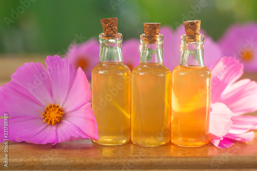 Essence of  flowers on table in beautiful glass Bottle