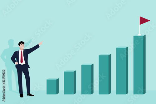 Business man pointing finger to flag on top of highest bar graph.