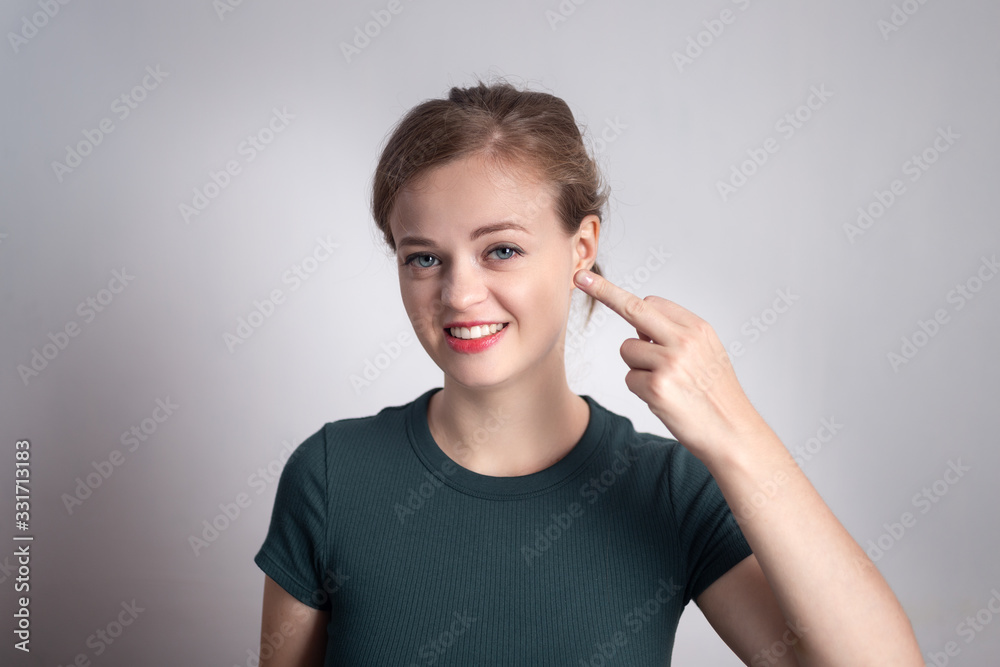 Young caucasian woman smiles, shows middle finger Young caucasian woman smiles, shows middle finger