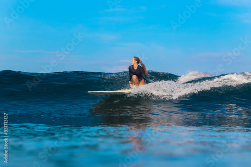 Female surfer on a wave © trubavink
