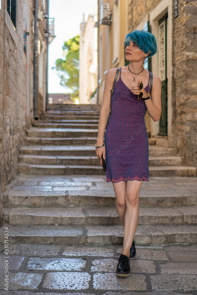 Girl blogger in a purple dress walks the streets of the old city