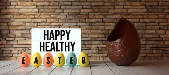 easter eggs with message HAPPY HEALTHY EASTER with big chocolate egg in front of a brick wall