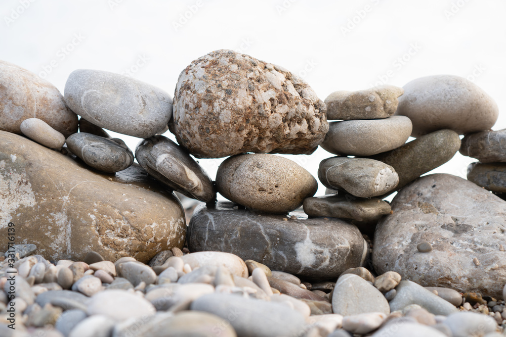 Abstract composition of pebbles stacked on top of each other on the shore Abstract composition of pebbles stacked on top of each other on the shore