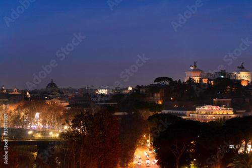 Fototapeta Naklejka Na Ścianę i Meble -  Night longexposure shot of the magnificent city of Rome seen at sunset time from a garden on the hills, some famous monuments are visible 