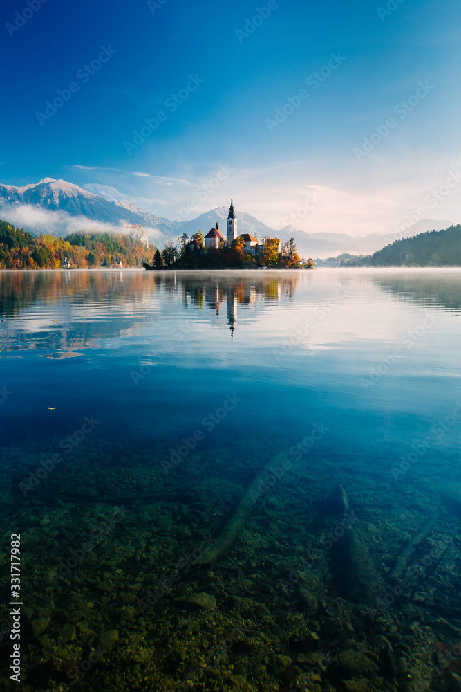 Fototapeta premium Amazing view on a misty morning of lake Bled with St. Marys Church of the Assumption on the small island; Bled, Slovenia, Europe.