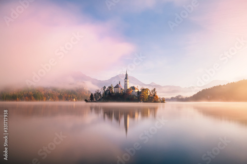 Amazing view on a misty morning of lake Bled with St. Marys Church of the Assumption on the small island; Bled, Slovenia, Europe.