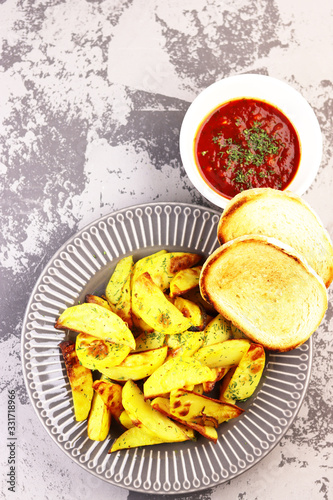 Fototapeta Naklejka Na Ścianę i Meble -  fried potatoes on a plate with tomato sauce