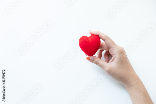 Female hand holding a red heart