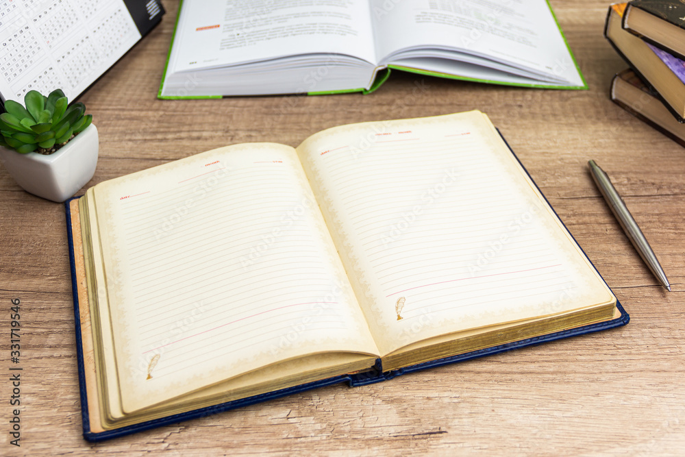 Workplace ready for writing open notebook with pen for your text on background open book and books stuck Workplace ready for writing open notebook with pen for your text on background open book and books stuck
