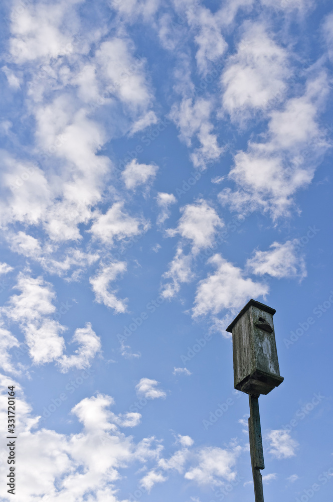 Rustic birdhouse on a background of sky with cirrus clouds. Waiting for Spring. Rustic birdhouse on a background of sky with cirrus clouds. Waiting for Spring.