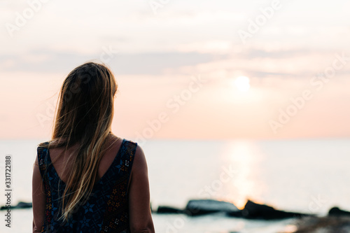Young woman enjoying sunset on the beach