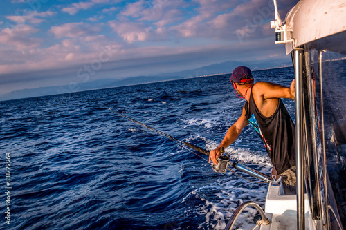 The brutal young man on sea fishing. Trolling.