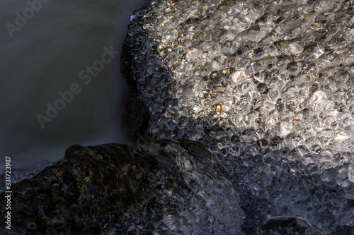 Clear ice in the brook in winter. Small frozen balls.